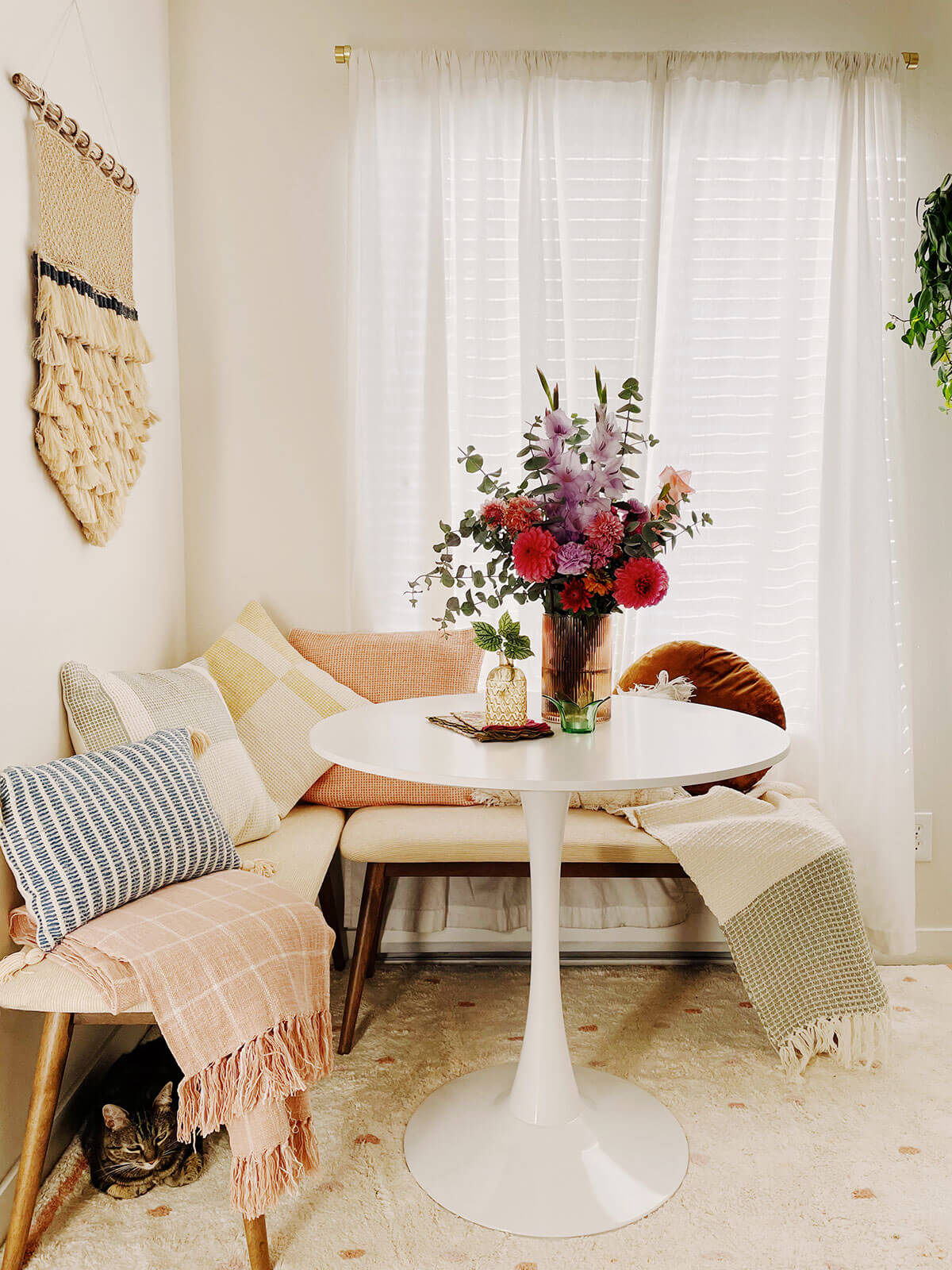 A light and bright dining nook with colorful pillows