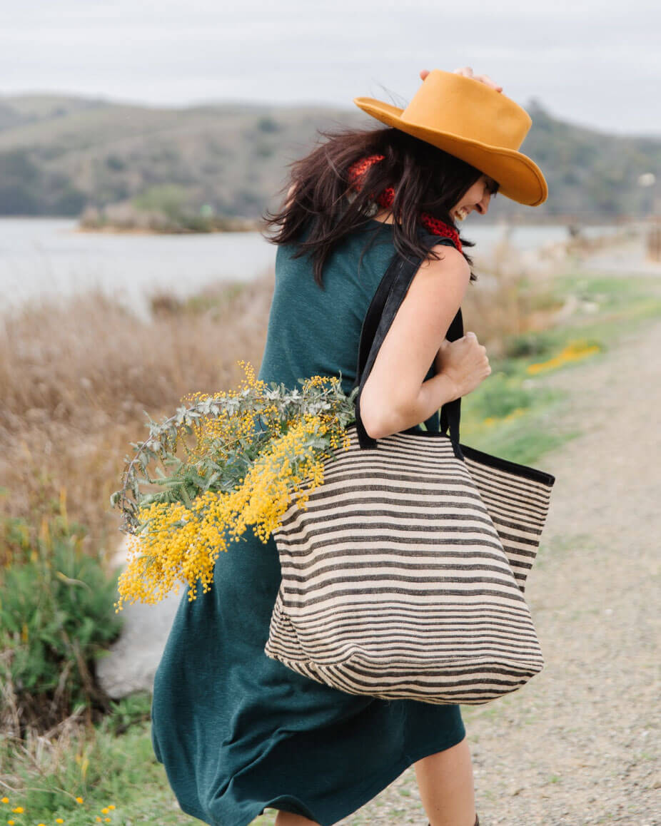 woman wearing striped farmers market tote bag with flowers, by will + atlas