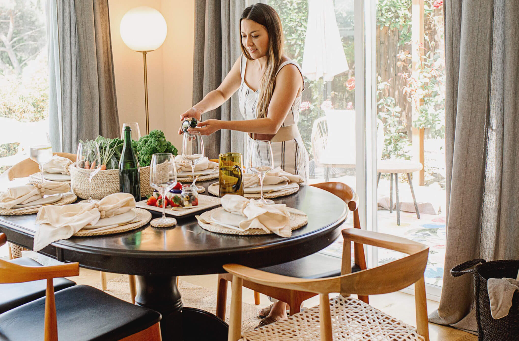 woman setting modern minimalist dining table with fair trade decor by will + atlas