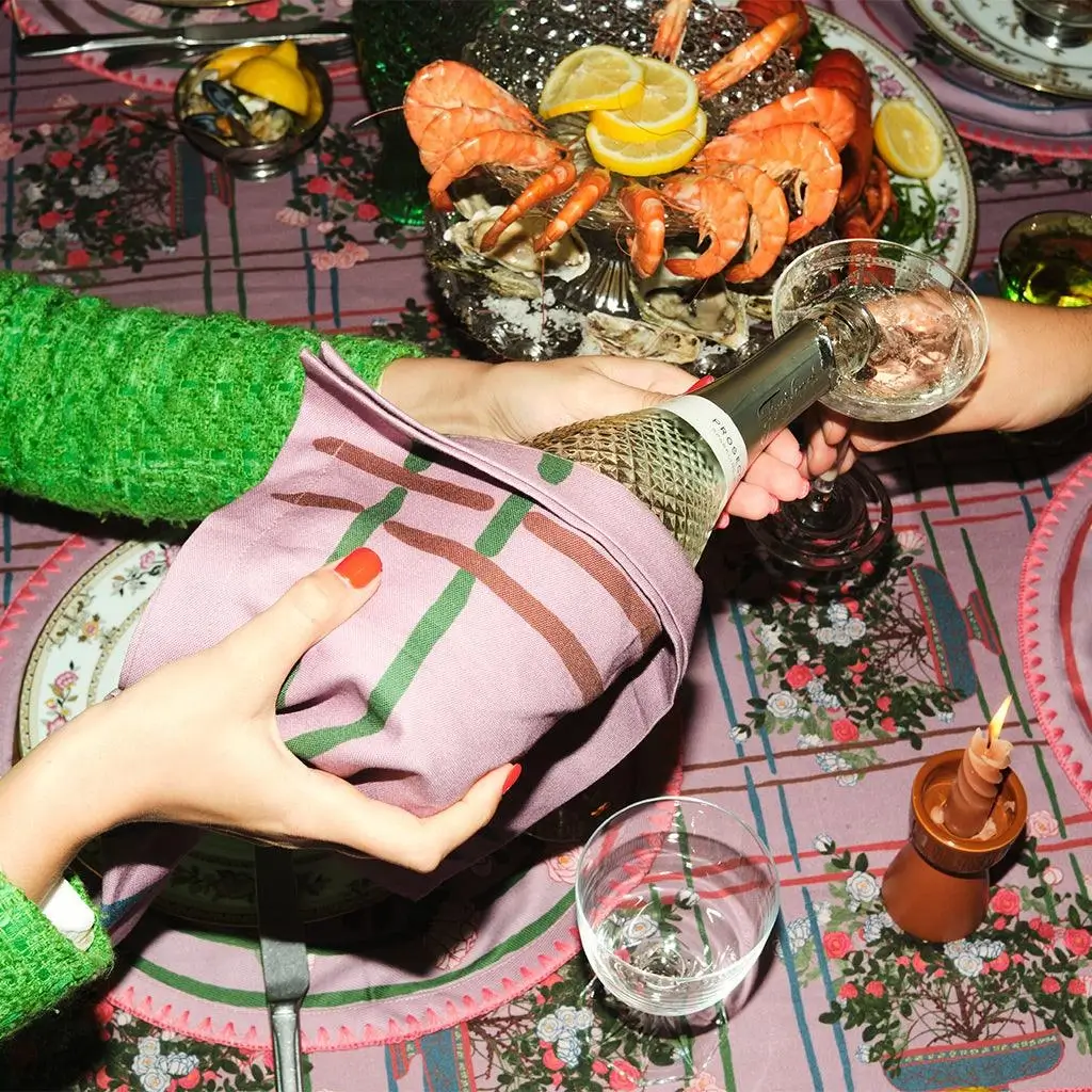 woman pouring champagne with luxury table linens